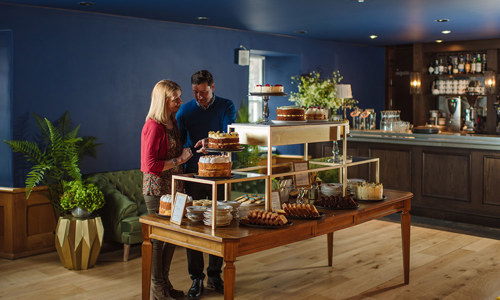 Interior of the front area of the Tea Rooms with a couple choosing cakes from a cake table