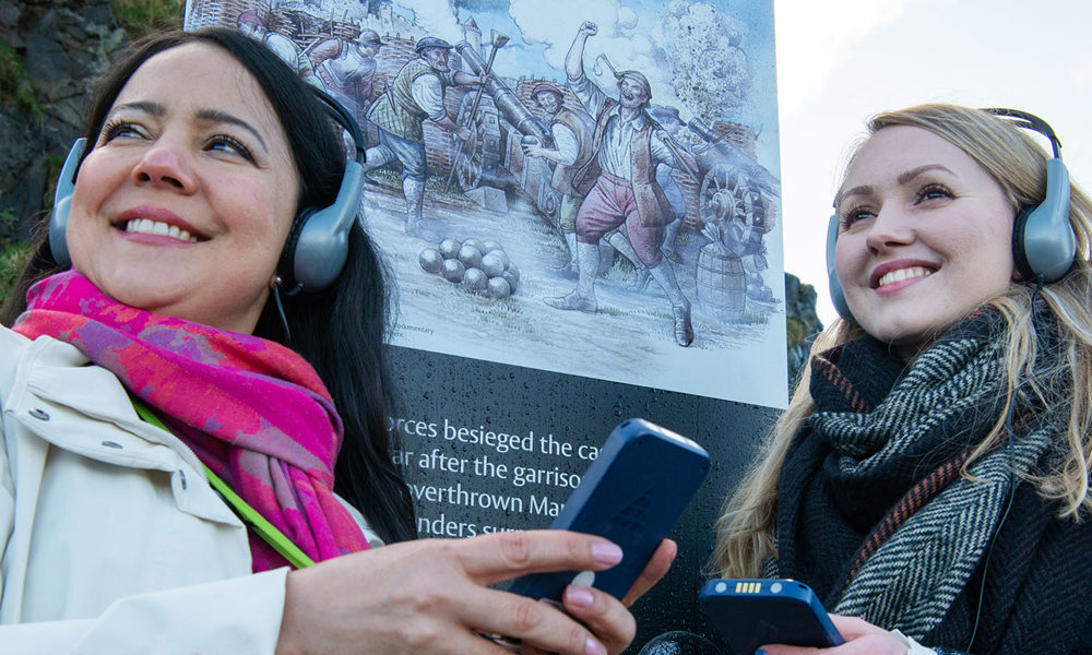 Two women at the castle listening to the new audio guide