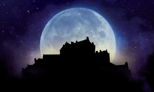 Silhouette image of Edinburgh Castle with a large moon in the background