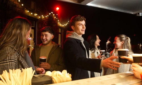 A group of people grabbing hot chocolates at a Benugo cafe at the castle