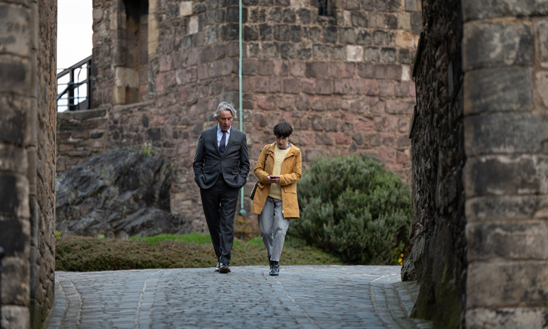 Two people walking down towards Foog's Gate, the steepest part of Edinburgh Castle