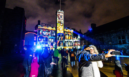 A couple taking a selfie in crown square during castle of light
